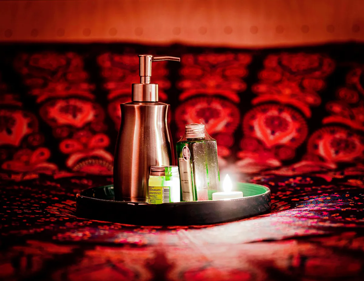 Massage oils on tray against mandala bedspread — The Wild Nest, Ferrara