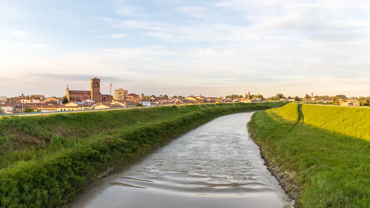 Bondenese canal with village on the horizon, Po plain
