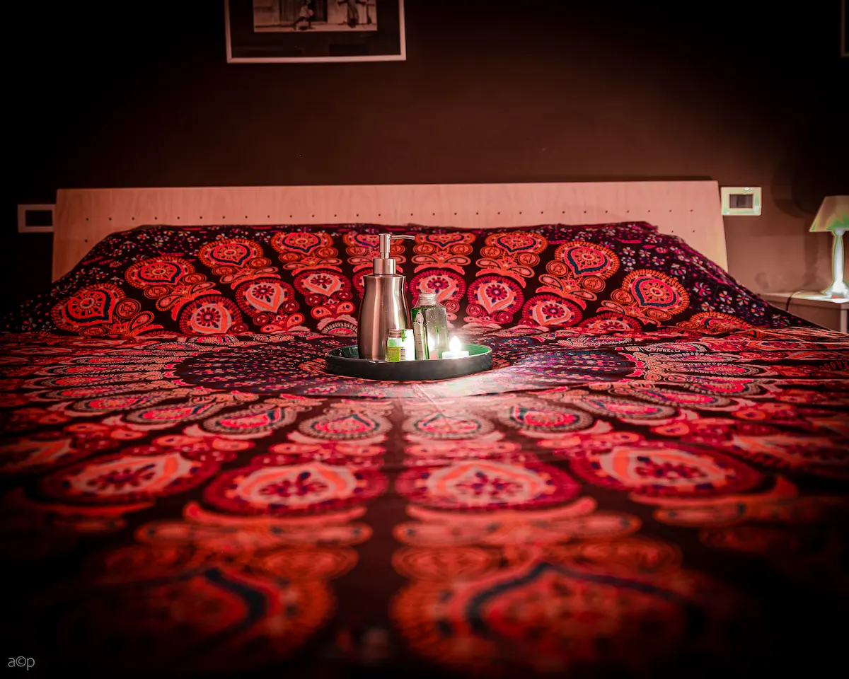 Mandala bedspread with massage oils tray — The Wild Nest, Ferrara